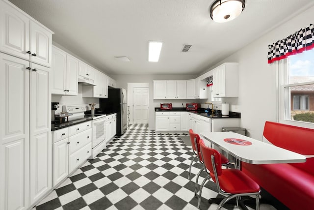 kitchen with white cabinetry, white electric stove, and stainless steel refrigerator