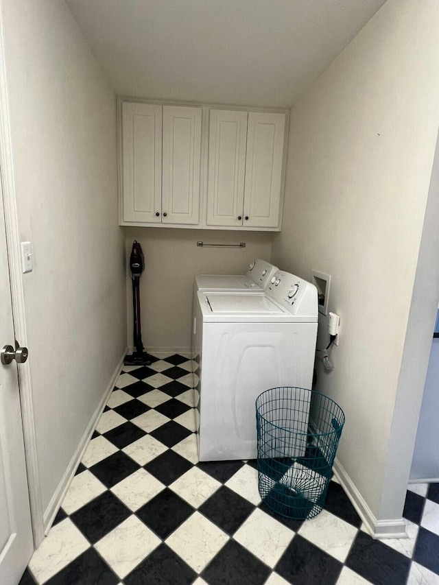 washroom featuring cabinets and washer and clothes dryer