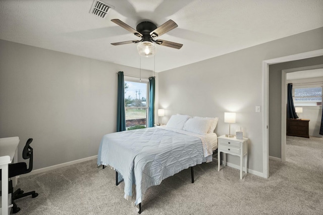 carpeted bedroom with multiple windows and ceiling fan