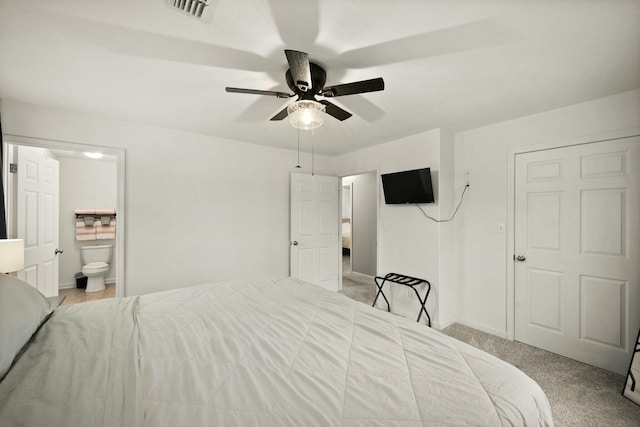 carpeted bedroom featuring ceiling fan and ensuite bath