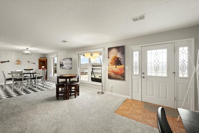 foyer entrance featuring carpet flooring and a textured ceiling