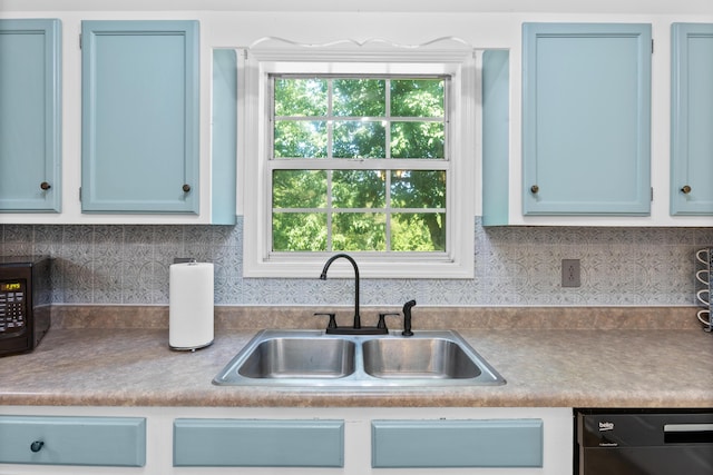 kitchen with a healthy amount of sunlight, sink, stainless steel dishwasher, and blue cabinets