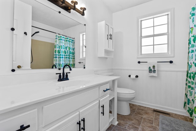 bathroom featuring a shower with shower curtain, vanity, and toilet