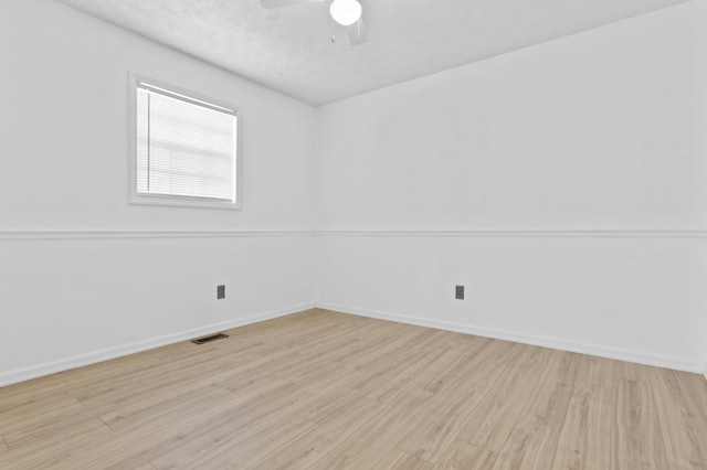 empty room featuring a textured ceiling, light hardwood / wood-style flooring, and ceiling fan