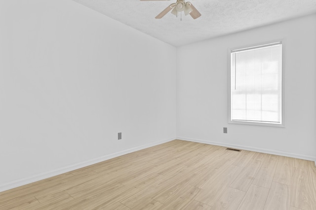 unfurnished room with ceiling fan, light wood-type flooring, and a textured ceiling