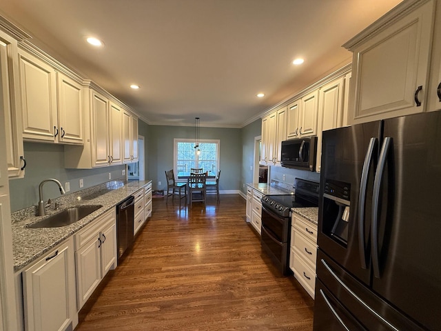 kitchen featuring ornamental molding, dark wood-type flooring, sink, black appliances, and pendant lighting