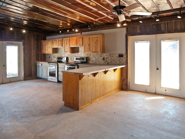 kitchen with a kitchen bar, electric range, kitchen peninsula, and french doors