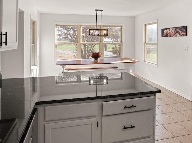 kitchen featuring decorative light fixtures, white cabinets, light tile patterned floors, and a chandelier