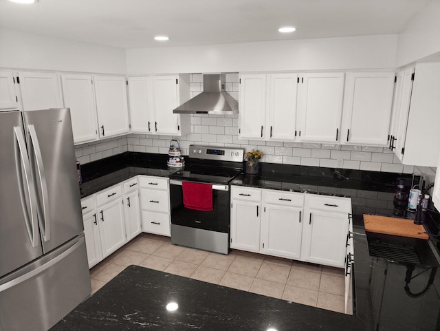 kitchen featuring light tile patterned flooring, appliances with stainless steel finishes, white cabinets, and wall chimney range hood