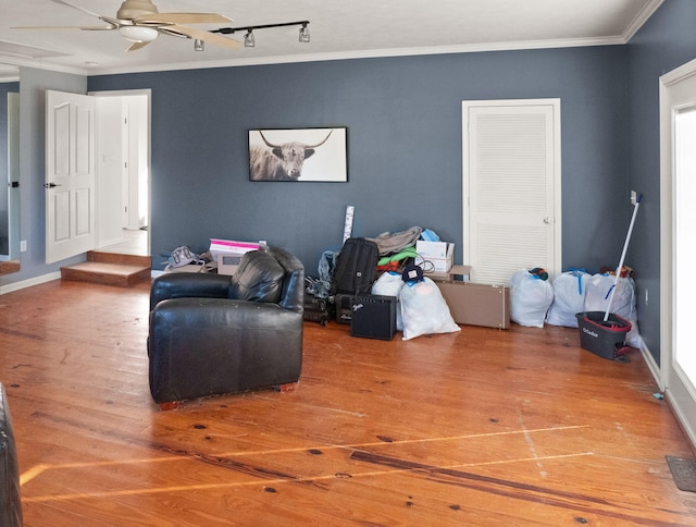 living area featuring ceiling fan, crown molding, and wood-type flooring