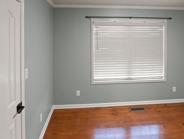 empty room featuring ornamental molding and wood-type flooring