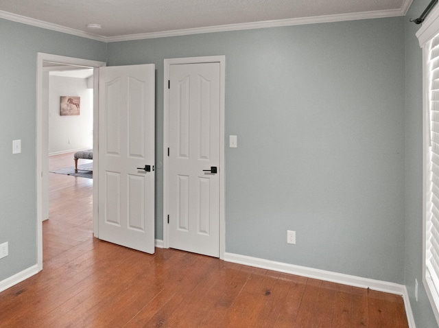 unfurnished bedroom featuring hardwood / wood-style flooring and ornamental molding