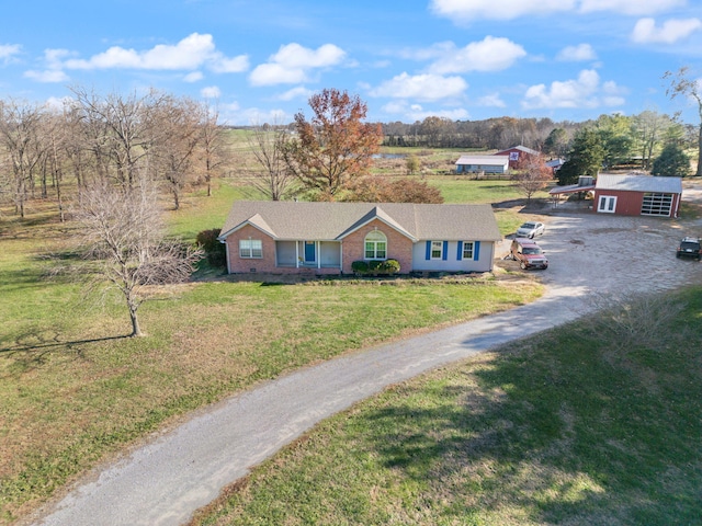 view of front of house with a garage, a front lawn, and an outbuilding