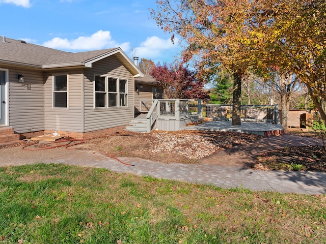 back of property featuring a deck and a yard