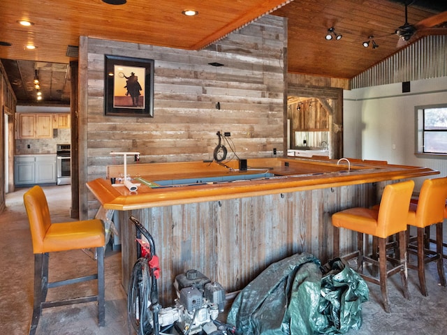 bar featuring wooden ceiling, range, lofted ceiling, and wooden walls