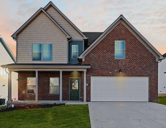 view of front of property featuring brick siding, concrete driveway, covered porch, a front yard, and a garage