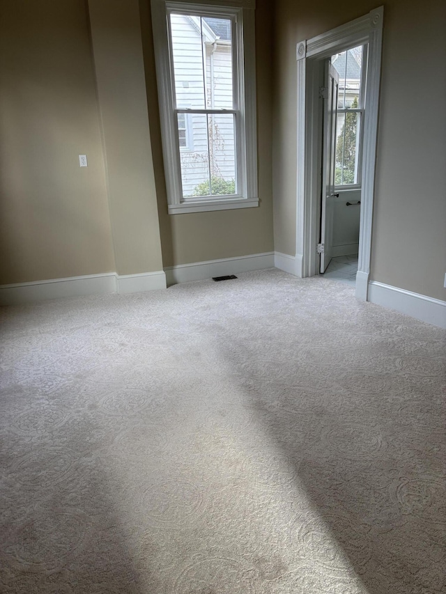 carpeted spare room featuring a healthy amount of sunlight