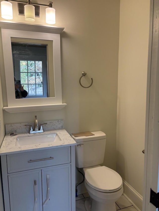 bathroom featuring tile patterned floors, vanity, and toilet