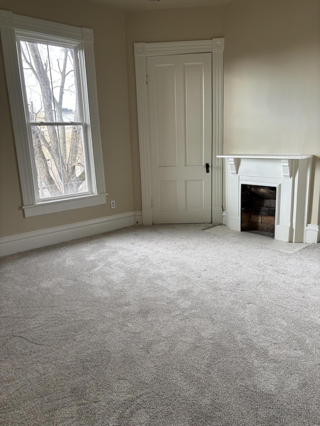 unfurnished living room featuring carpet flooring and a healthy amount of sunlight