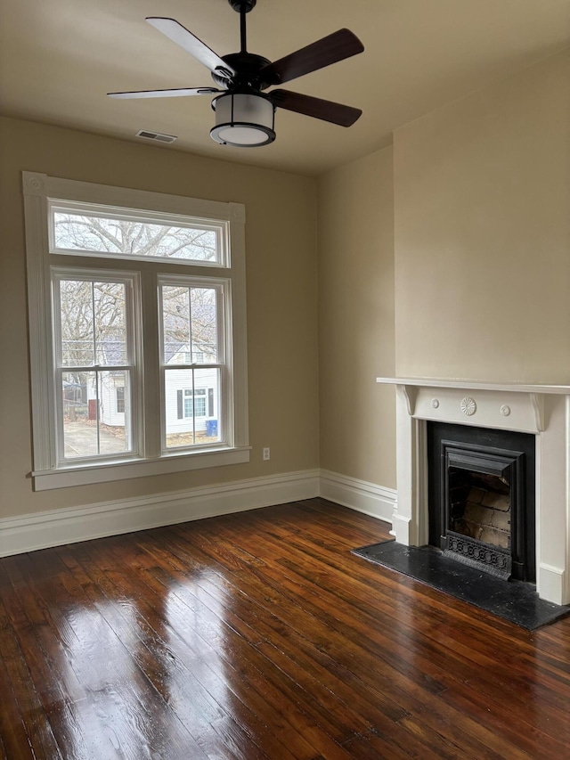 unfurnished living room featuring ceiling fan and dark hardwood / wood-style flooring