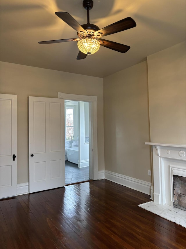 unfurnished living room with ceiling fan and dark wood-type flooring