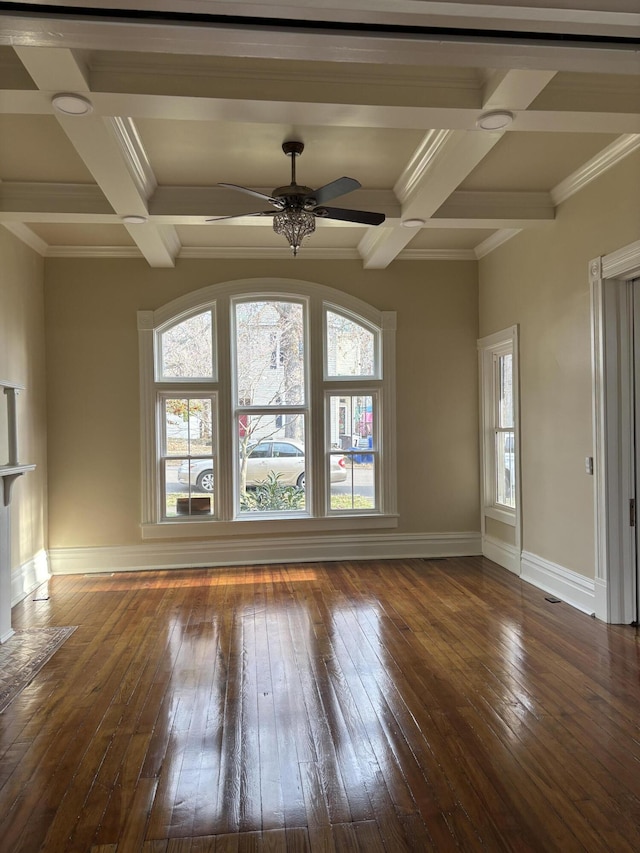 unfurnished living room featuring beam ceiling, dark hardwood / wood-style flooring, ceiling fan, and crown molding