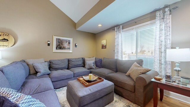 living room featuring light wood-type flooring and vaulted ceiling