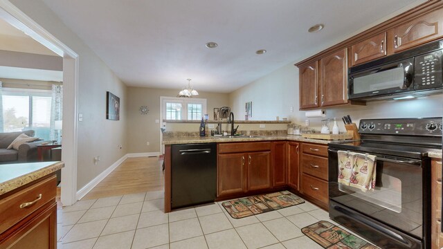 kitchen featuring black appliances, a notable chandelier, sink, and light tile patterned floors