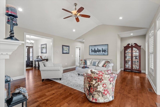 living room with ceiling fan with notable chandelier, dark hardwood / wood-style floors, and lofted ceiling