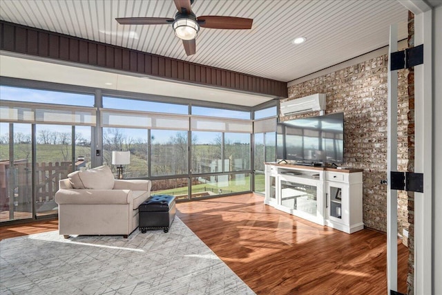 interior space with hardwood / wood-style floors, plenty of natural light, ceiling fan, and an AC wall unit