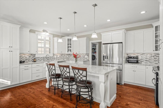 kitchen with a center island, white cabinetry, stainless steel appliances, and a breakfast bar area