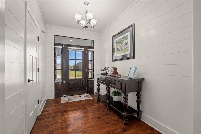 entrance foyer featuring crown molding, dark wood-type flooring, and a chandelier