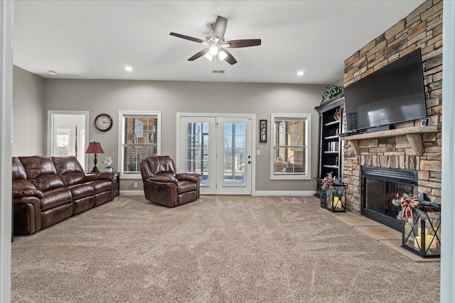 carpeted living room with ceiling fan and a fireplace