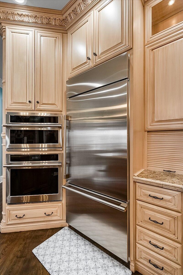 kitchen featuring light stone countertops, light brown cabinetry, and appliances with stainless steel finishes