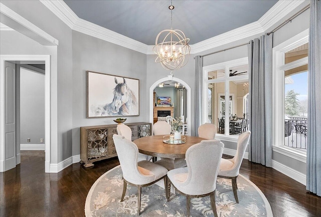 dining space with dark wood-type flooring, a chandelier, and ornamental molding