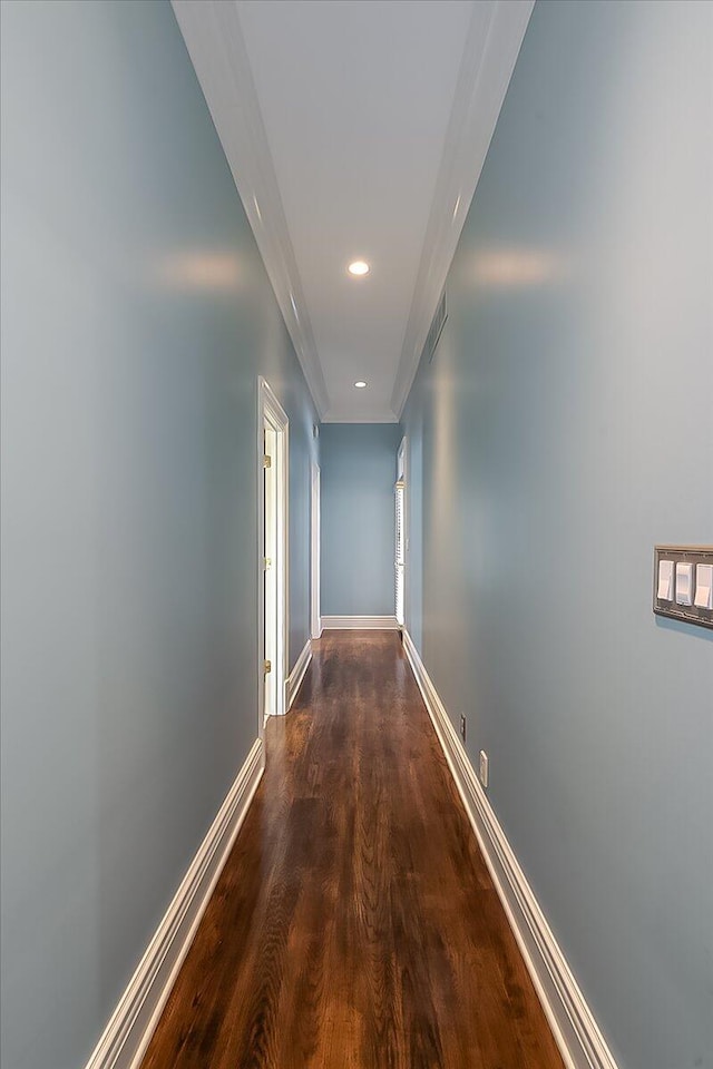 hall with dark hardwood / wood-style flooring and ornamental molding