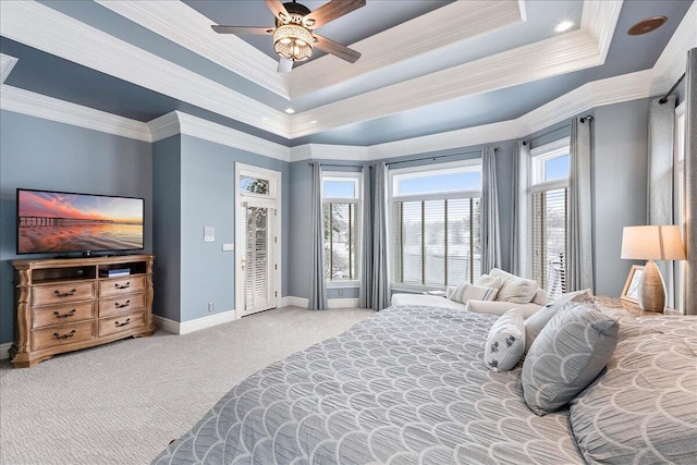 bedroom featuring carpet, ceiling fan, ornamental molding, and a tray ceiling