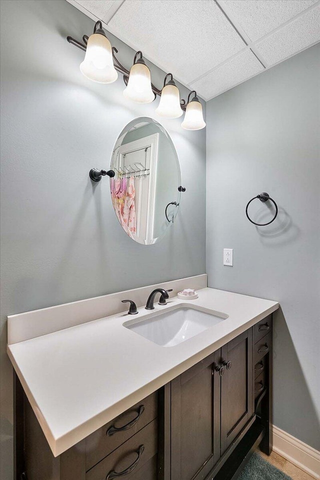 bathroom with a paneled ceiling and vanity