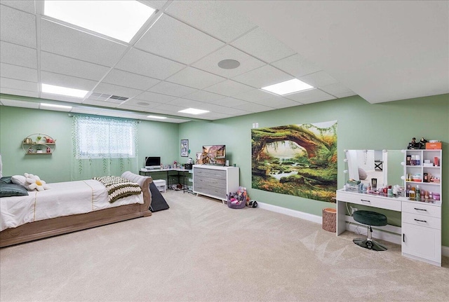 bedroom with a paneled ceiling and light carpet