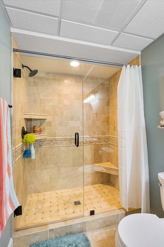 bathroom with tile patterned flooring, toilet, and walk in shower