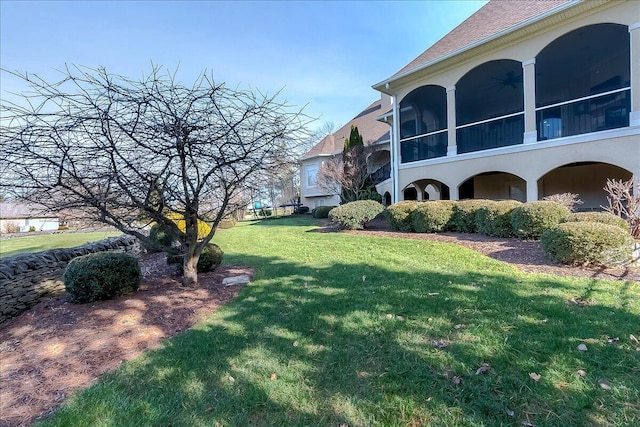 view of yard with a sunroom and ceiling fan