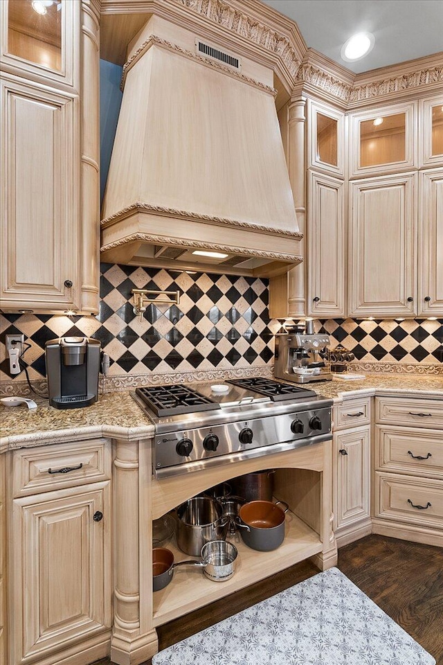 kitchen featuring tasteful backsplash, light stone counters, custom exhaust hood, dark wood-type flooring, and stainless steel gas stovetop