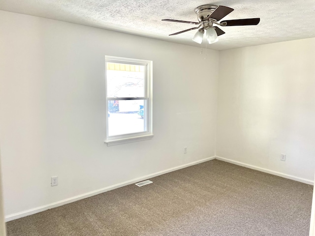 carpeted empty room with a ceiling fan, baseboards, visible vents, and a textured ceiling