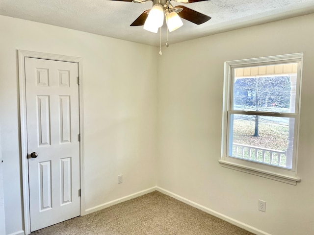 unfurnished room featuring a ceiling fan, light carpet, a textured ceiling, and baseboards