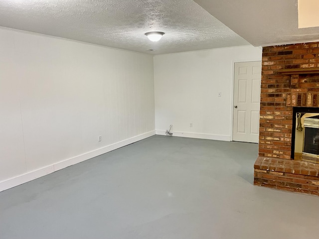 below grade area with a fireplace, a textured ceiling, and baseboards