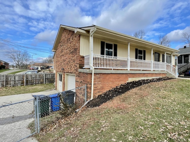 view of front facade featuring driveway, an attached garage, fence, a porch, and brick siding