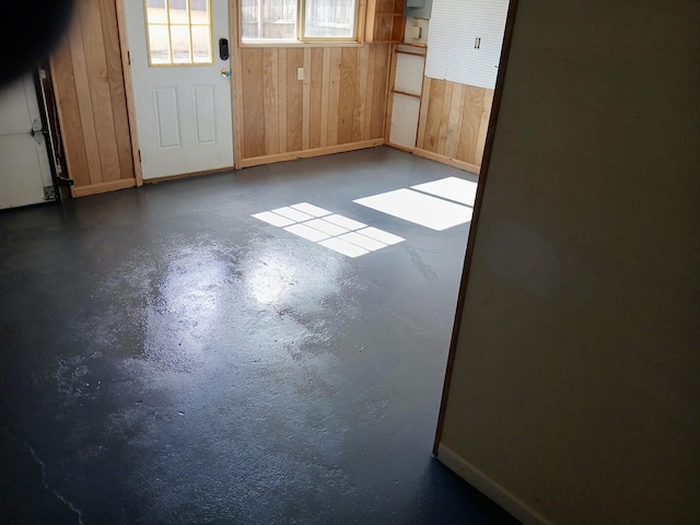 interior space with finished concrete flooring and wooden walls