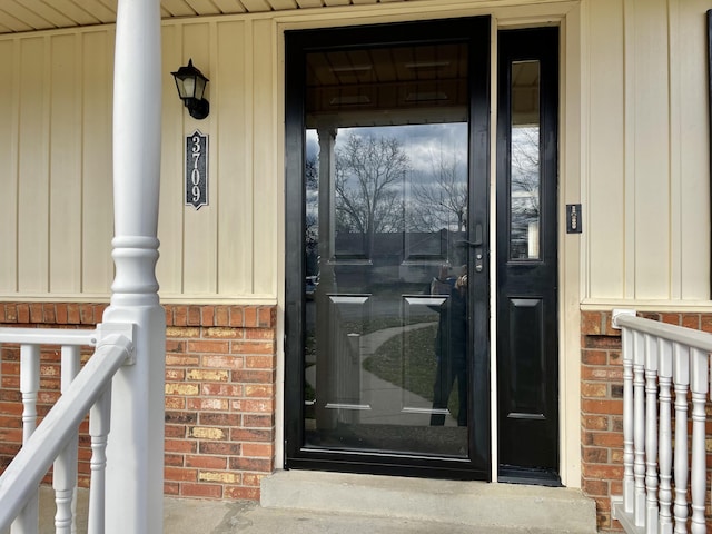 doorway to property with brick siding