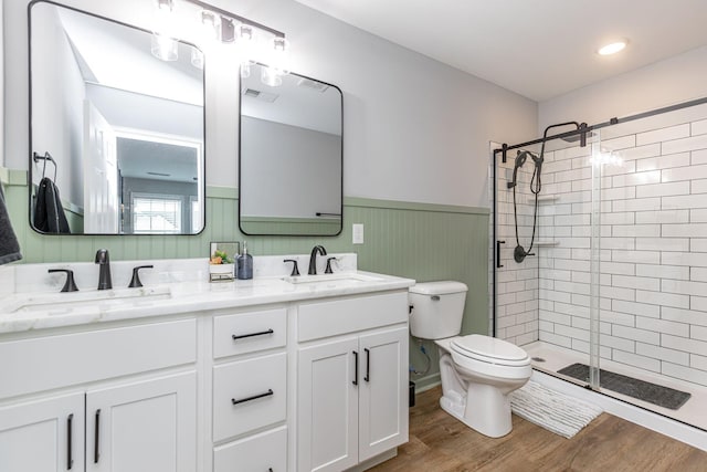 bathroom featuring toilet, vanity, a shower with shower door, and hardwood / wood-style flooring