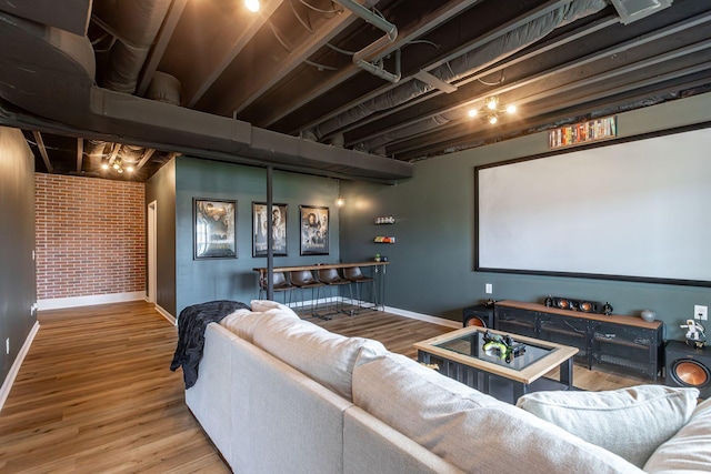 cinema with bar area, hardwood / wood-style floors, and brick wall